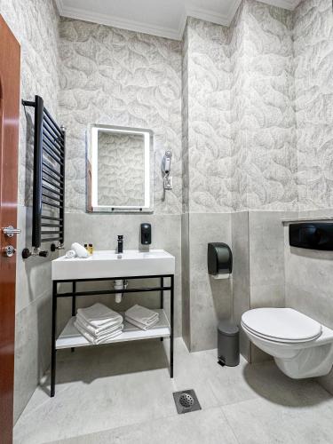 a bathroom with a sink and a toilet at Hotel Vidović in Banja Luka