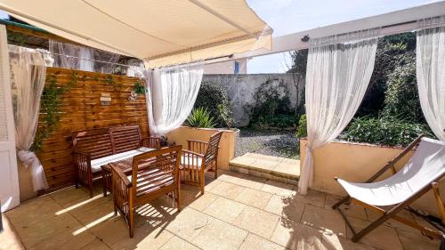 a patio with a table and chairs and an umbrella at Rêve D'azur plage de la Nartelle studio 20m2 avec piscine partagée, parking Barbecue, draps inclus à la Nartelle in Sainte-Maxime