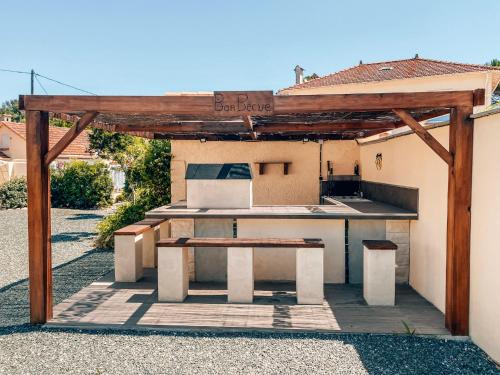 a outdoor kitchen with a table and a bench at Rêve D'azur plage de la Nartelle studio 20m2 avec piscine partagée, parking Barbecue, draps inclus à la Nartelle in Sainte-Maxime