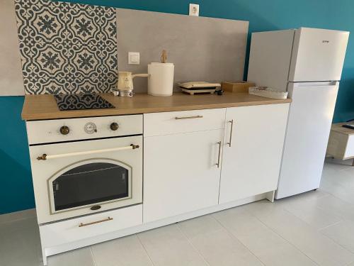 a kitchen with a white stove and a refrigerator at Blue Eye in Amfilochía