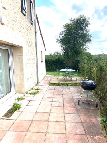 a patio with a bbq grill and a table at La maison de Méguillaume proche Haras du Pin - 5 pers in Gouffern en Auge