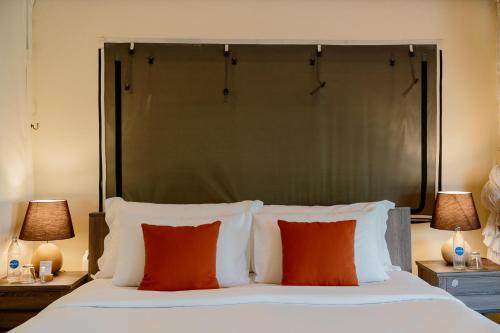 a bedroom with a large bed with red pillows at Te Mata Glamping in Nong Nam Daeng