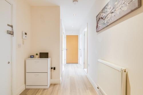 a hallway with white walls and a white refrigerator at Modern Living Stevenage 2bed Apartment Town Centre up to 8 people Tesco at Doorstep in Stevenage