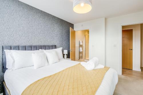 a bedroom with a large bed with white pillows at Modern Living Stevenage 2bed Apartment Town Centre up to 8 people Tesco at Doorstep in Stevenage