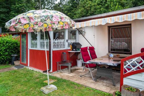 a house with a table and an umbrella in the yard at Haus Seeblick in Malchow