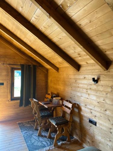 drewniana jadalnia ze stołem i krzesłami w obiekcie Cottages Serdar w mieście Mojkovac