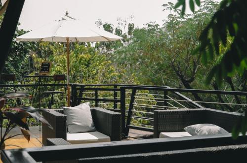 a patio with two chairs and an umbrella at Te Mata Glamping in Nong Nam Daeng