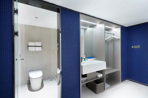 un baño con inodoro y lavabo en Atour Light Hotel Nanjing Chengxin Avenue Subway Station, en Jiangning