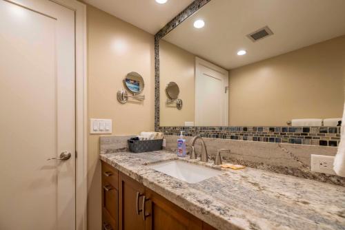 a bathroom with a sink and a large mirror at Kihei Beach Resort 608 in Kihei