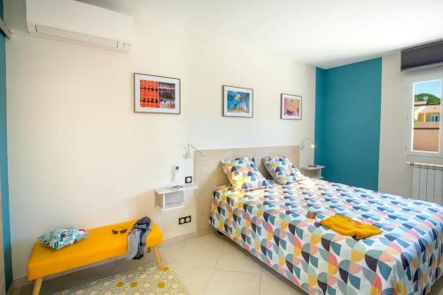 une chambre avec un lit et un banc dans l'établissement Caloussu-Calme-Moderne-Clim, à Roquebrune-sur Argens