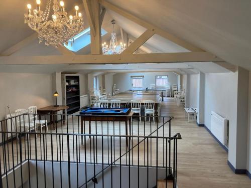 une grande salle avec une salle à manger et un lustre dans l'établissement Maison entière de 2 à 10 personnes, à Sées