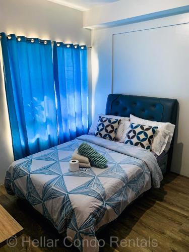 a bedroom with a blue bed with a blue curtain at HELLAR Condo Rentals in Bacolod