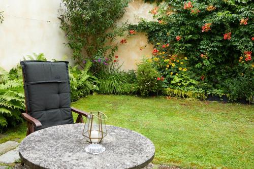 a table and a chair in a garden with flowers at Guesthouse with 3 apartments, just outside Berlin, near to Tesla in Burig