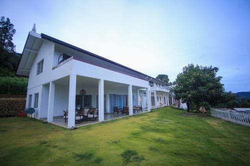 a large white house with a large yard at Benito Bungalow, Haputale by The Serendipity Collection in Haputale