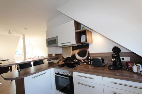 a kitchen with white cabinets and a staircase in it at Ferienwohnung Petra in Neumarkt in der Oberpfalz