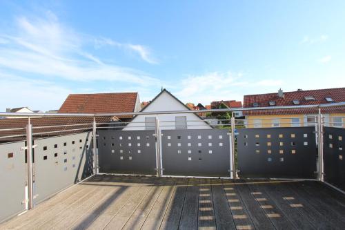 a rooftop deck with a fence and buildings at Ferienwohnung Petra in Neumarkt in der Oberpfalz