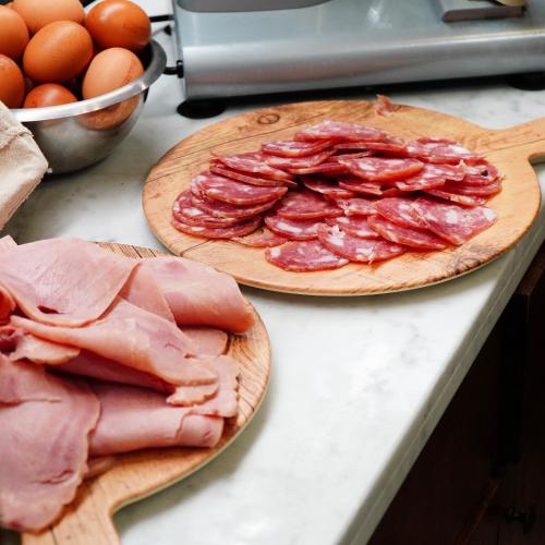 two plates of bacon and meat on a counter at Puteoli Palace Hotel in Pozzuoli