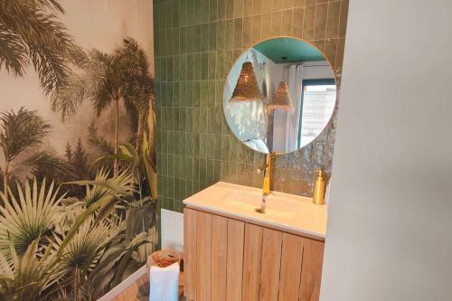 een badkamer met een wastafel en een spiegel bij Villa IrisJasmin jacuzzi vue mer in Lacanau