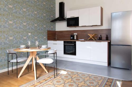 une cuisine avec une table et un réfrigérateur dans l'établissement OIQIA • Berry, à Bourges