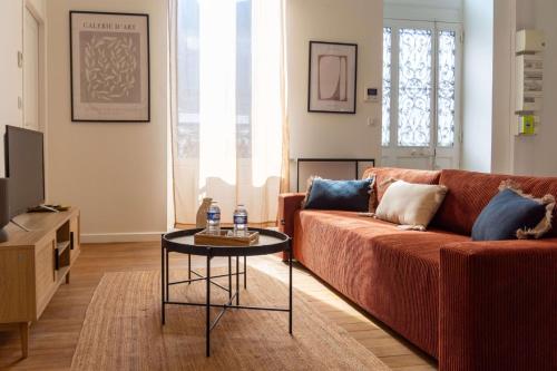 un salon avec un canapé rouge et une table dans l'établissement OIQIA • Berry, à Bourges