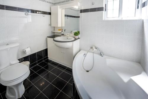 a bathroom with a toilet and a tub and a sink at Kos Center Katerina in Kos Town
