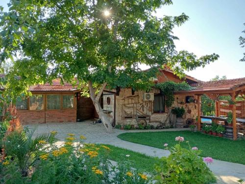 a house with a tree and a yard at Мехса in Svetoslav