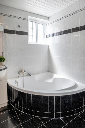 a bath tub in a bathroom with black and white tiles at Kos Center Katerina in Kos Town