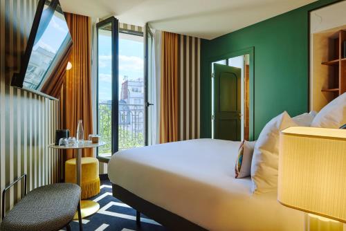 a hotel room with a bed and a window at Mercure Paris Butte Montmartre Basilique in Paris