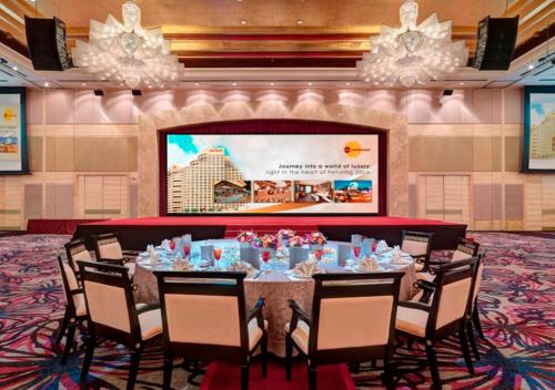 a conference room with a long table with chairs and a screen at One World Hotel in Petaling Jaya