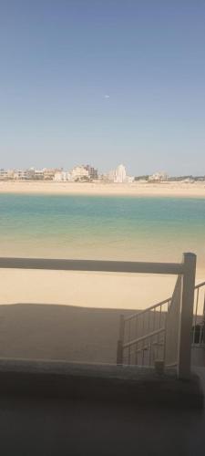 a view of a beach with a bench and the ocean at شاليه عائلات فقط in An Nāmī