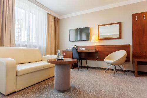 a hotel room with a couch and a desk at Hotel Tarnovia in Tarnów