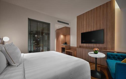 a bedroom with a white bed and a tv at PARKROYAL Langkawi Resort in Pantai Cenang