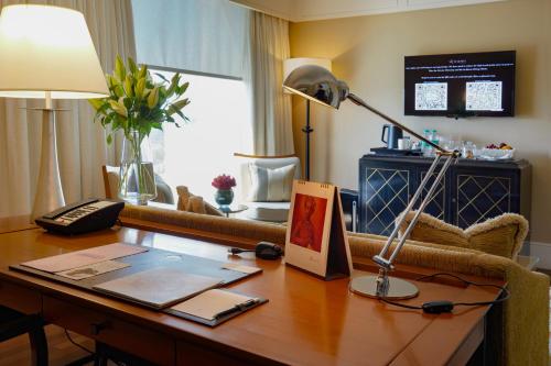 an office with a desk with a lamp and a couch at The Leela Mumbai in Mumbai