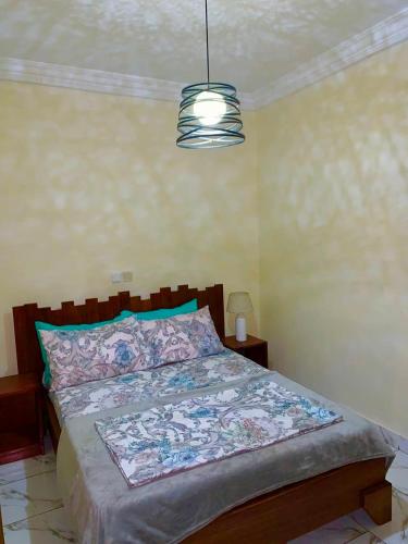 a bedroom with a large bed with a large bedspread at Residence Ethan Nji - Green Heaven in Yaoundé