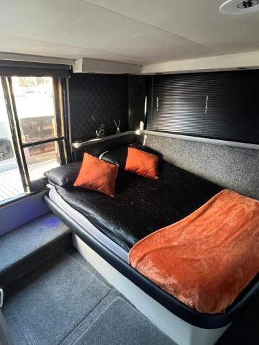 a bed in the back of a train with two pillows at YACHT "X" - 44 FOOT MODERN YACHT ON 5 STAR OCEAN VILLAGE MARINA - minutes away from city centre and cruise terminals, Free parking ,SPA package available! in Southampton