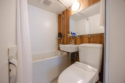 東京にあるホテル ウイング インターナショナル新橋御成門の白いトイレと洗面台のあるバスルーム