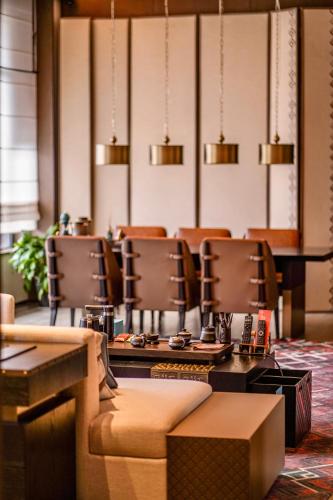 a dining room with chairs and tables and lights at Hotel Indigo Jiuzhai by IHG in Jiuzhaigou