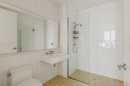 a white bathroom with a sink and a shower at Blueground Clinton Hill roof pool doorman wd NYC-1550 in Brooklyn