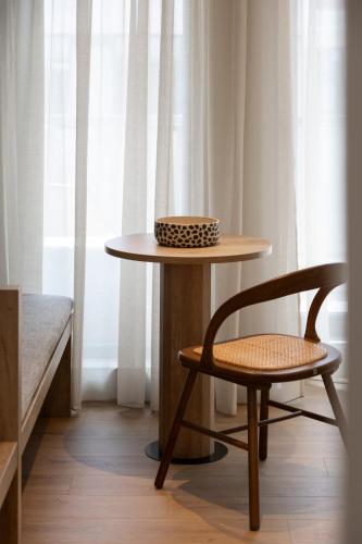 a table and a chair next to a window at Rebalance Apartments in Athens