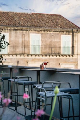 a group of chairs sitting at a bar in front of a building at Palazzo Sangiorgio in Catania