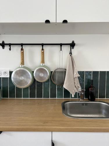 eine Küchentheke mit Töpfen und Pfannen, die an der Wand hängen in der Unterkunft Les Loges des Coteaux - Loge 2 - Luxury lodges with jacuzzi in Blaye