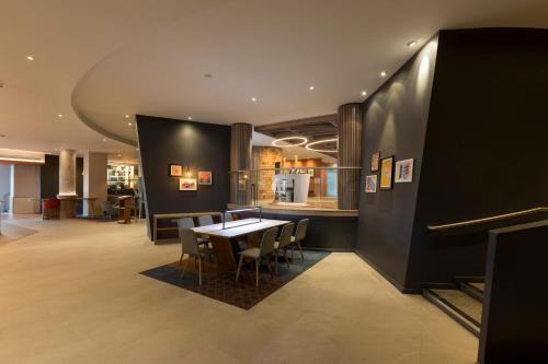a dining room with a table and chairs and a kitchen at Holiday Inn Edinburgh Zoo by IHG in Edinburgh