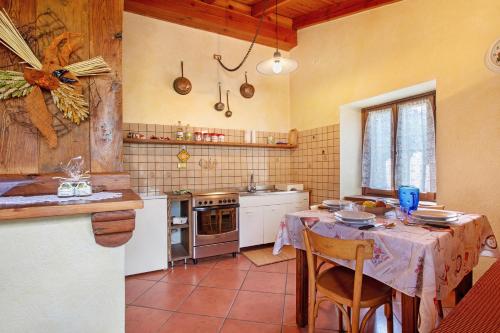 a kitchen with a table with chairs and a stove at Alloggio La Tour in Saint-Pierre