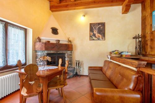 a living room with a couch and a table and a fireplace at Alloggio La Tour in Saint-Pierre