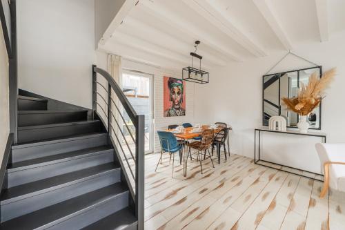 une cuisine et une salle à manger avec un escalier, une table et des chaises dans l'établissement Le clos des Aviateurs - Belle maison à Strasbourg, à Strasbourg