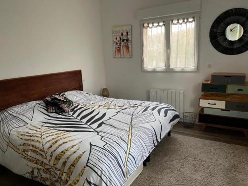 a bedroom with a bed with a black and white comforter at Ty Coogee in Herbignac