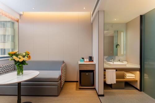 a bathroom with a couch and a sink in a room at Holiday Inn Express Shanghai Jing'an Temple by IHG in Shanghai