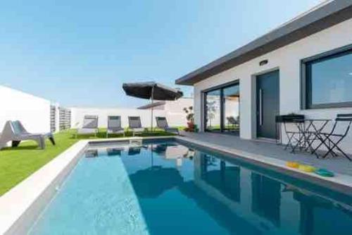 a swimming pool in front of a house at Tequila House - Luxury House in Portugal in Mariquiteira