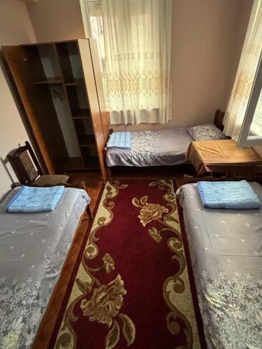 a room with three beds and a red carpet at Tazo's Guest House in K'obulet'i
