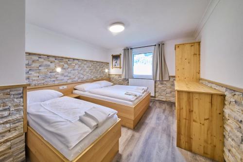 a room with two beds and a window at Ski & Bike Appartements Forsthaus in Saalbach Hinterglemm